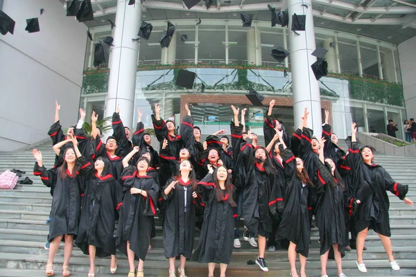 Kinesiska Akademiker Klädd Studentexamen Klänningar Kasta Sina Hattar Luften Examensceremoni — Stockfoto