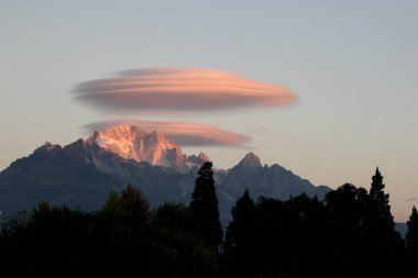View of UFO shaped clouds above the Jade Dragon Snow Mountain, also known as the Yulong Snow Mountain, in Lijiang city, southwest Chinas Yunnan province, 4 December 2005 clipart
