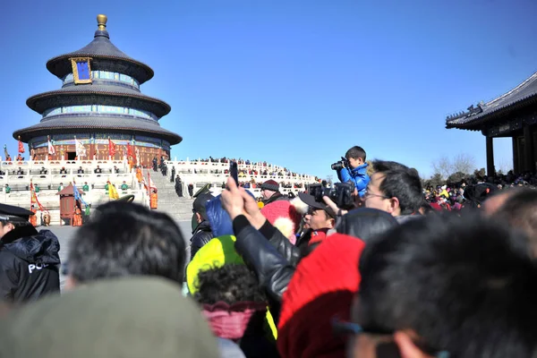 観光客は 中国の天の神殿で豊かな収穫のための祈りのホールの前で中国の新年や春祭りのための古代の王室の天国の礼拝式を見ます 2014年2月3日 — ストック写真