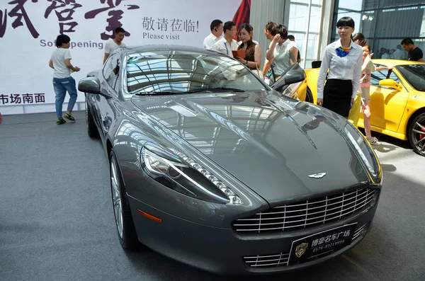 File 訪問者は 2013年6月10日 中国浙江省東部のウェンリング市で行われた自動車ショーでアストンマーティンの車を見ます — ストック写真