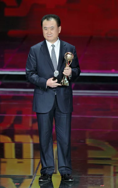 大连万达集团董事长王建林在2012年12月12日于中国北京举行的2012年中国经济人士年度经济颁奖典礼上与奖杯合影 — 图库照片