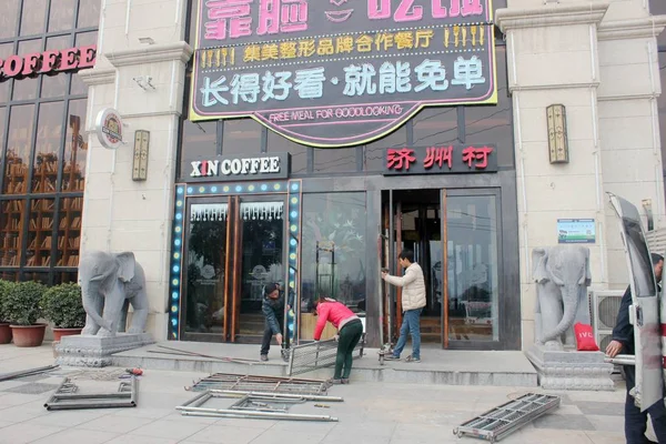 2015年1月13日 中国工人在中国中部的河南省郑州市建造一个脚手架 从餐厅的外墙拆除广告牌 为好看的顾客提供免费餐食 — 图库照片