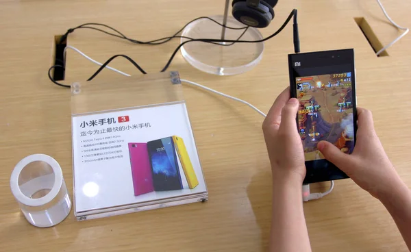 2014年5月2日 中国中部湖北省武汉市一家小米店 一位顾客在小米智能手机上玩手机游戏 — 图库照片