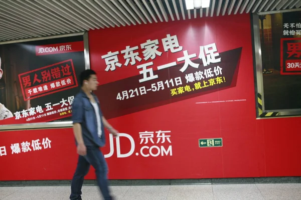 歩行者は 2014年4月27日 北京の地下鉄駅で オンラインショッピングサイトJd Com 旧Jingdong Comと呼ばれていた の広告を通り過ぎる — ストック写真