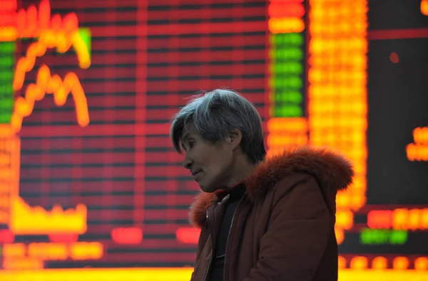 Китайский Инвестор Выглядит Обеспокоенным Перед Экраном Показывающим Фондовые Индексы Биржевом — стоковое фото