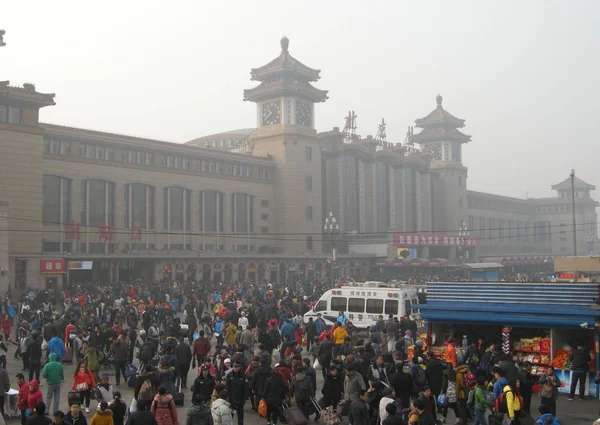 行って帰って旧正月や北京 中国の春祭りのため 2014 中国の乗客が北京駅の広場で見られています — ストック写真