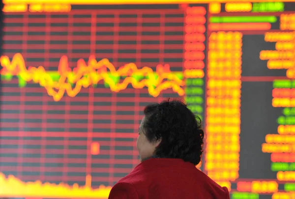 2014年4月17日 中国东部安徽省阜阳市一家股票经纪公司的中国投资者查看股票指数 — 图库照片