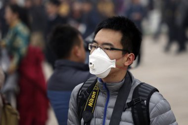 A reporter wearing a face mask waits in heavy smog outside the Great Hall of the People during the Opening Session for the Second Session of the 12th National Committee of the CPPCC (Chinese Peoples Political Consultative Conference) in Beijing, Chin clipart