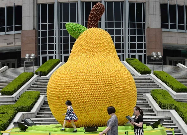 2014年5月30日 在中国上海大门户广场前 人们走过镶嵌着15000多只橡皮鸭的巨型梨子 — 图库照片
