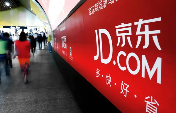 歩行者は 2013年5月31日 上海の地下鉄駅で Jingdong Comまたは360Buy Comと呼ばれていたオンラインショッピングサイトJd Comの広告を通り過ぎる — ストック写真