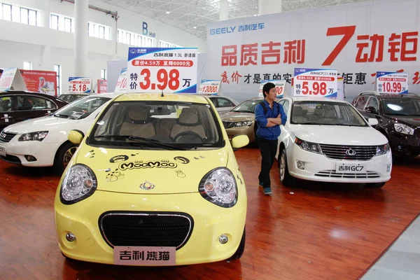2014年3月22日 在中国海南省海口市举行的车展上 一位参观者走过吉利汽车 — 图库照片