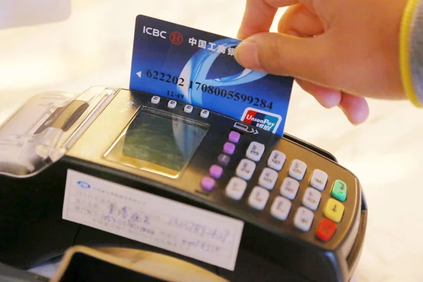 2013年10月25日 中国中央省河南省徐昌市の店舗で支払いを受け付けている中国工業商業銀行 Icbc のクレジットカードを レジ係がスワイプする — ストック写真