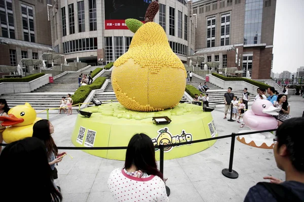 2014年6月2日 在中国上海大门户广场前 人们看着巨大的梨子 上面镶嵌着15000多只橡皮鸭 其中近一半被偷了 — 图库照片