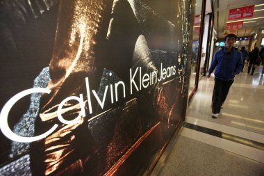 A customer walks past a Calvin Klein Jeans (CK Jeans) boutique at a shopping mall in Shanghai, China, 4 February 2013 clipart