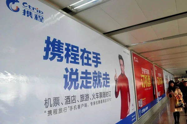 歩行者は 中国の中国のオンライン旅行代理店Ctripの広告を通り過ぎる 2014年3月2日 — ストック写真