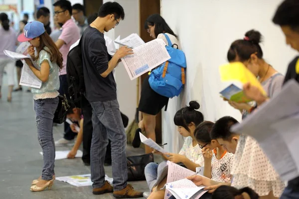 Los Graduados Chinos Están Pie Cuclillas Mientras Miran Información Del — Foto de Stock