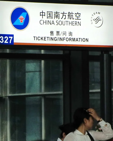 ファイル 乗客は 中国の空港で中国南方航空の発券とインフォメーションデスクを通り過ぎる 2011年9月23日 — ストック写真
