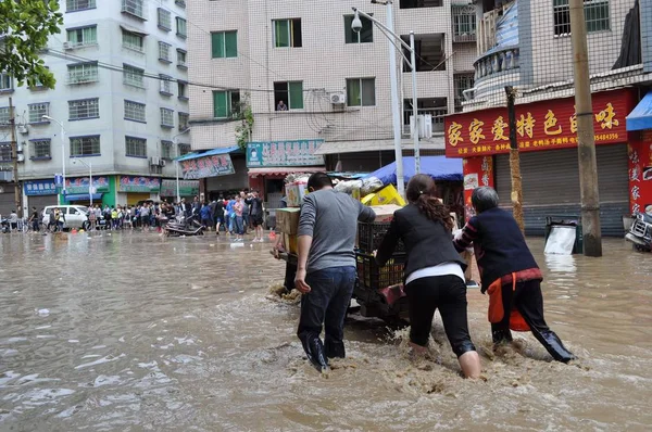 地元の中国人住民は 2014年6月3日 中国南西部貴州省 ツンジ郡 ズニイ市 南西部の暴風雨によって浸水した道路にフラットベッド三輪車を押す — ストック写真