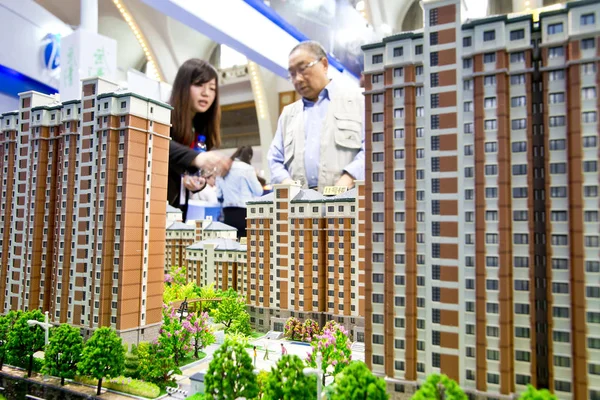 2014年4月10日 中国北京房地产交易会期间 一名中国员工向购房者介绍住宅公寓楼 — 图库照片