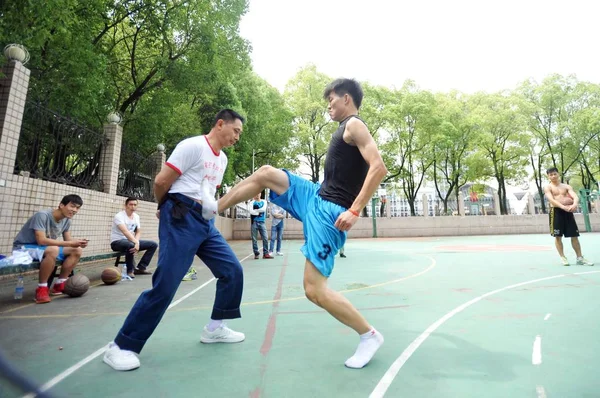 若い男キック謝レベル 2014 日バスケット ボール裁判所 中央中国湖北省武漢市でサンドバッグとして彼自身を提供することによって生活を作る人 — ストック写真