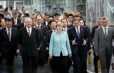 German Chancellor Angela Merkel, center, is accompanied by Volkswagen CEO Martin Winterkorn, second left, FAW Group Chairman Xu Jianyi, behind Merkel, and other officials and executives as they visit the auto plant of FAW-Volkswagen in Chengdu city,  clipart