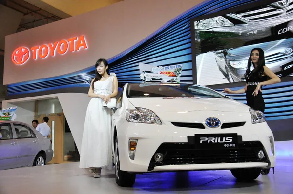 モデルは 青島市 東中国山東省 2012 月14日に自動車展示会の間にトヨタのプリウスハイブリッド車でポーズ — ストック写真