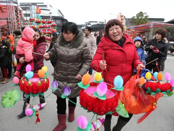 地域住民が 2014 日東中国江蘇省南京市の市場で今後のランタン フェスティバルのため買ったランタンを運ぶ — ストック写真
