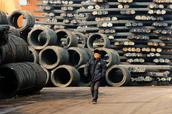 2014년 산둥성 칭다오시의 부두에서 노동자가 더미를 지나걷고 — 스톡 사진