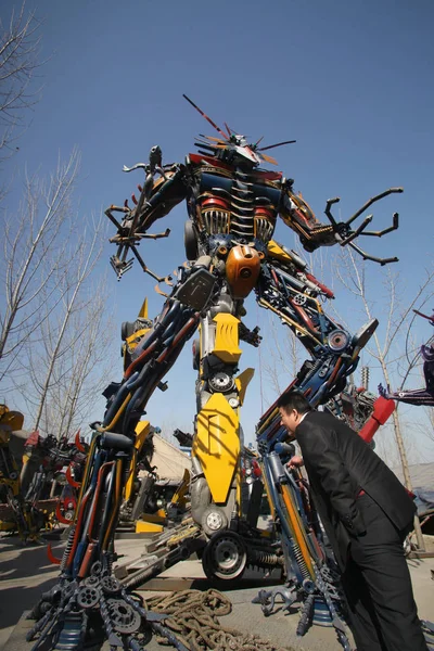 Китайський Чоловік Дивиться Роботів Зроблених Клаптики Транспортних Засобів Дворі Будинку — стокове фото