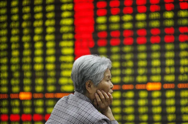 中国の投資家は Huaibei 東中国安徽州 の株式仲買家で株式の価格を見て 価格上昇のための赤 価格下落のためのグリーン 月2014 — ストック写真