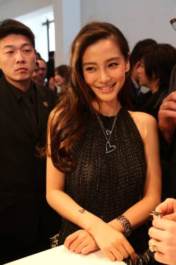 Hong Kong model and actress Angelababy, right, smiles during a promotional event for Calvin Klein watch in Shanghai, China, 11 March 2014. clipart