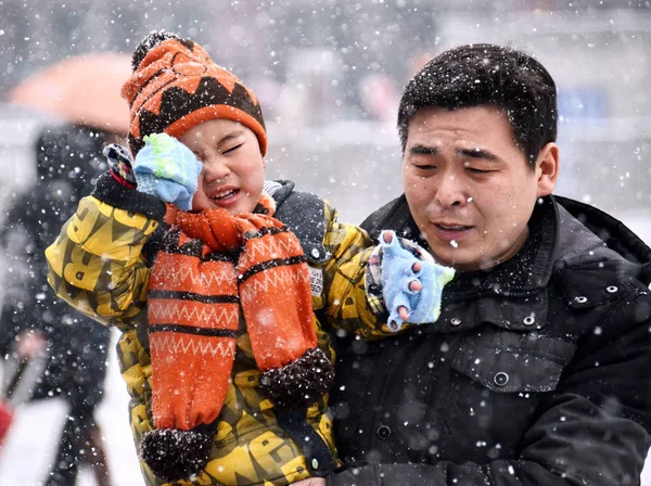 2014年2月5日 在中国中部河南省郑州市的郑州火车站重雪广场 一名抱着孩子的中国乘客从春节假期回来工作 — 图库照片