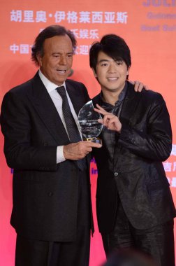Spanish singer-songwriter Julio Iglesias, left, poses with Chinese pianist Lang Lang after being presented with an award for First and Most Popular International Artist in China at a press conference in Beijing, China, 1 April 2013 clipart