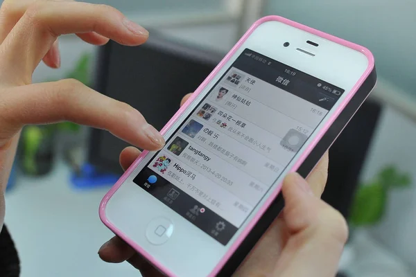 2013年4月23日 在中国东北辽宁省大连市 一名中国妇女在苹果 Iphone 智能手机上使用腾讯的手机短信应用微信 Wechat — 图库照片