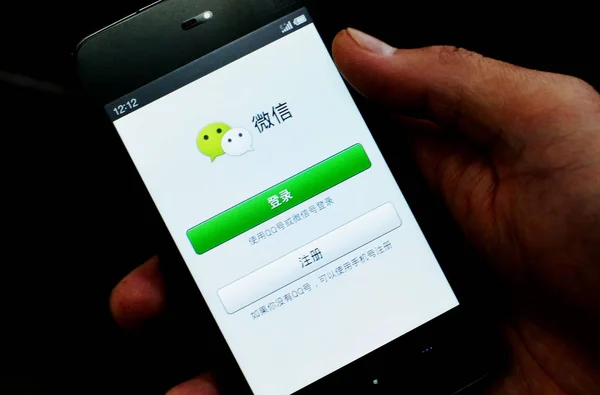 2013년 25일 톈진에서 남성이 텐센트의 메시징 Weixin Wechat을 스마트폰으로 사용합니다 — 스톡 사진