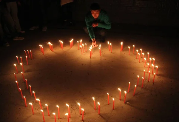 2013年4月25日 在中国中部河南省安阳市 一名当地市民在地震遇难者纪念馆点燃蜡烛 — 图库照片