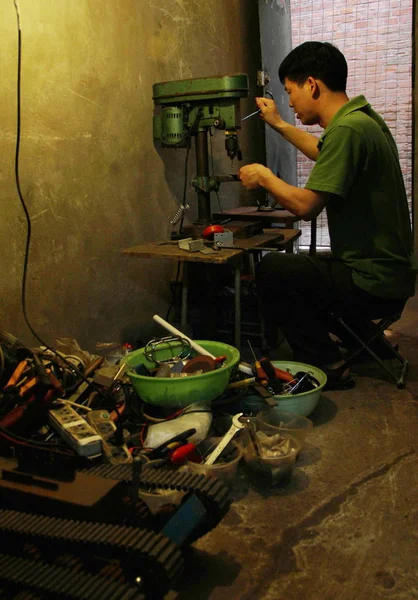 中国农民陶祥力在中国北京从事废零件的工作 用于组装他的机器人 2013年5月16日 — 图库照片