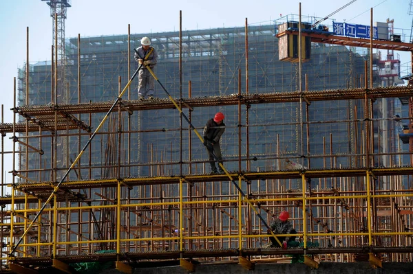 2013年4月7日 中国工人在中国东部浙江省杭州市一个房地产项目施工现场建造脚手架 — 图库照片