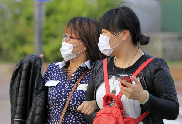 2013年4月15日江蘇省東中国南京市の通りでH7N9鳥インフルエンザに対する顔のマスクをした若い中国人女性 — ストック写真