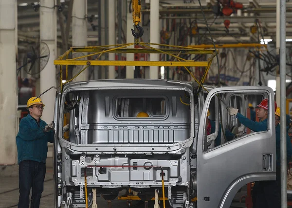 中国の従業員は 中国国家重労働グループのプラットフォームでトラックの製造ラインで働いています 中国南西部四川省 2013年3月31日 — ストック写真
