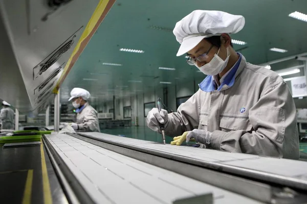 中国の工場労働者は楡 東中国江蘇省 2013 日の工場でヨーロッパに輸出される太陽光発電パネルをチェックします — ストック写真