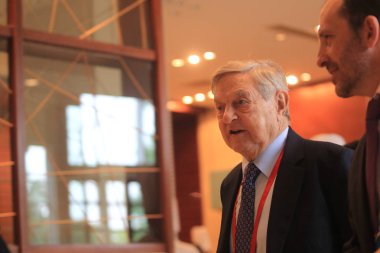 George Soros (left), chairman of Soros Fund Management and founder of The Open Society Institute, arrives at a meeting during the 2013 Boao Forum for Asia in Boao town, Qionghai city, south Chinas Hainan province, 7 April 2013.   clipart
