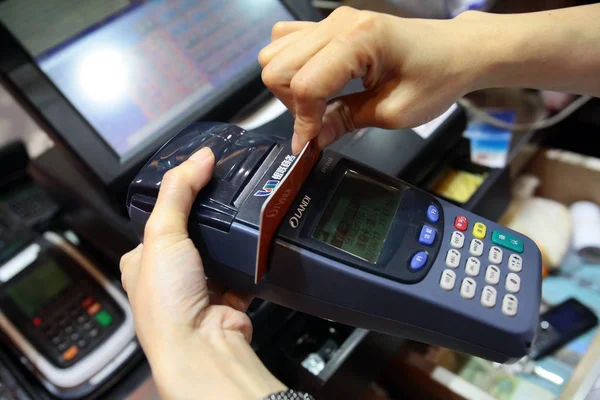 ファイル 中国書記官 2012 上海の店で支払いのための顧客のクレジット カードをスワイプします — ストック写真