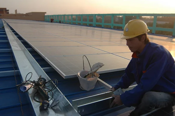 中国の労働者は 2012年10月30日 中国東部山東省 遼城市の広西郡の広西グループの繊維工場で ワークショップの屋上にソーラーパネルを設置します — ストック写真