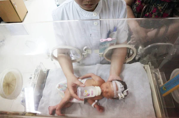 2013年5月28日 中国浙江省金华市一家医院的一所居民楼的下水道管道中 一名中国护士为婴儿喂食 — 图库照片