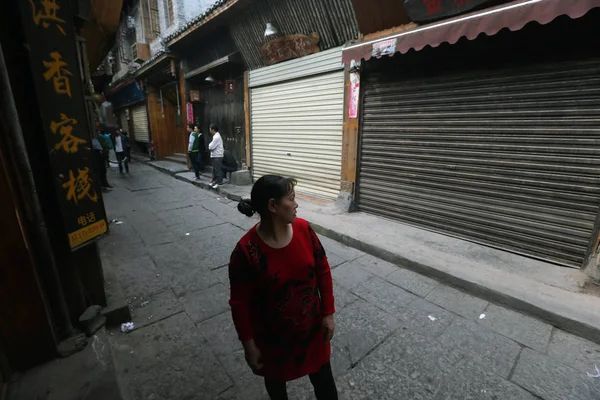 2013年4月15日 在中国中部的湖南省凤黄市 一位中国游客走过一条空荡荡的街道上的一家封闭商店 — 图库照片