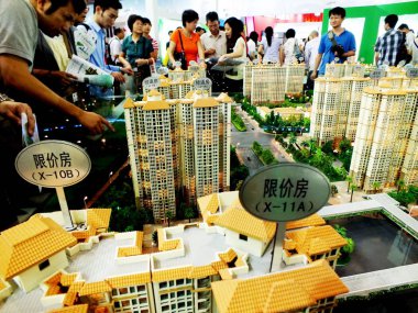 Chinese homebuyers view housing models during a real estate fair in Guangzhou city, south Chinas Guangdong province, 14 September 2012 clipart