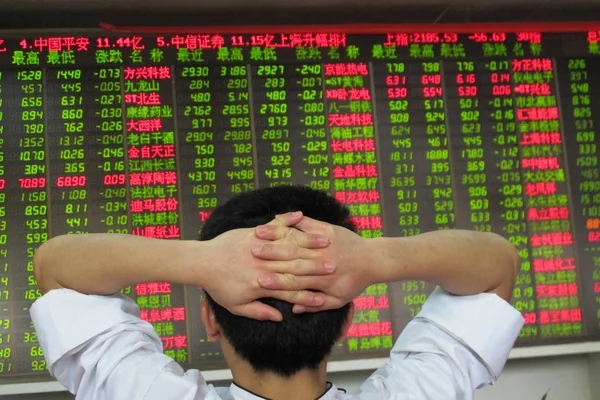 中国の投資家は 南中国海南省の株式仲買家で株式の価格をチェック 価格上昇のために赤 価格下落のために緑 月23日2013 — ストック写真