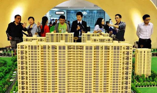 2012年10月9日 在中国东南部浙江省杭州市举行的房地产交易会上 购房者看一个住宅项目的模型并交谈 — 图库照片