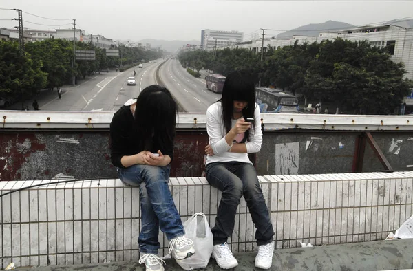 Due Giovani Lavoratrici Migranti Cinesi Usano Loro Telefoni Cellulari Una — Foto Stock